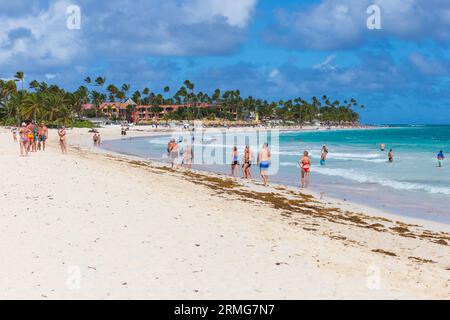 Bavaro, République Dominicaine - 10 février 2022 : Paysage de plage des Caraïbes. Les touristes sont sur la plage de Bavaro par une journée ensoleillée, côte de l'océan Atlantique Banque D'Images