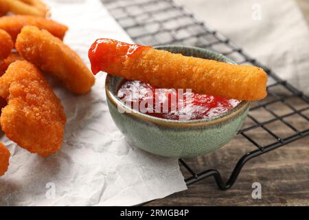 Savoureux nuggets de poulet, bâton de fromage et ketchup sur table en bois, gros plan Banque D'Images