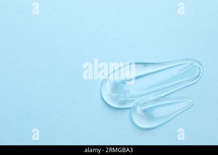 Swatches de gel cosmétique sur fond bleu clair, vue de dessus. Espace pour le texte Banque D'Images