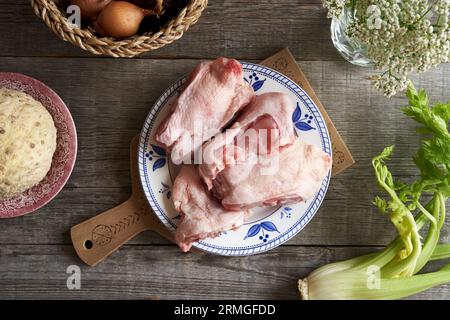 Dos de poulet crus surgelés à la racine de céleri et aux oignons - ingrédients pour bouillon d'os ou soupe Banque D'Images