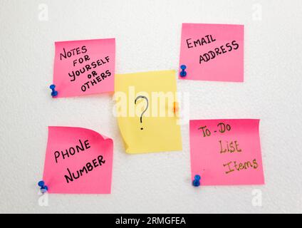 Une pile de notes autocollantes roses avec des symboles de point d'interrogation Banque D'Images