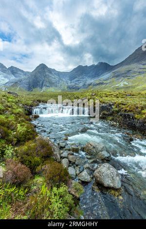 Cascade aux ciel dramatique et noire au-delà de montagnes Cuillin, Coire na Creiche, Glen cassante, Isle of Skye, Scotland, UK Banque D'Images