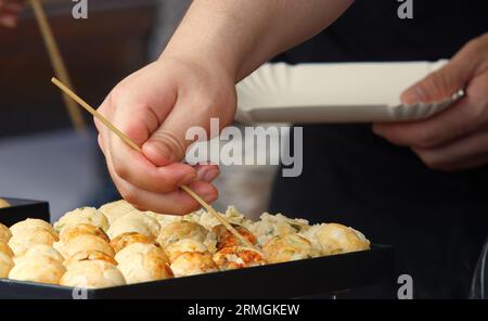 Les chefs de l'ambassade du Japon préparent des boulettes frites traditionnelles au festival des ambassades à Prague. Gros plan, flou partiel. Banque D'Images