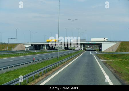 Wilczy Las, Pologne - 24 avril 2023 : le mouvement de transport de marchandises transportant des marchandises sur un survol de l'autoroute. Banque D'Images