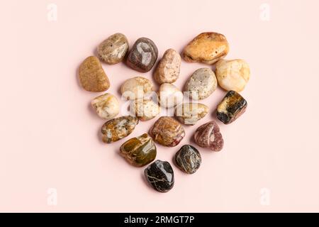 Coeur fait de pierres de galets sur fond rose Banque D'Images