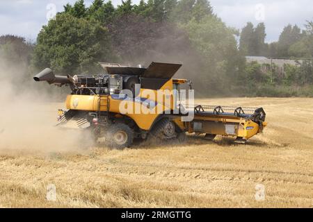 Terres agricoles près d'Airmyn près du pont Boothferry dans l'East Riding of Yorkshire UK.Une moissonneuse-batteuse récoltant une récolte de blé à la fin de l'été Banque D'Images