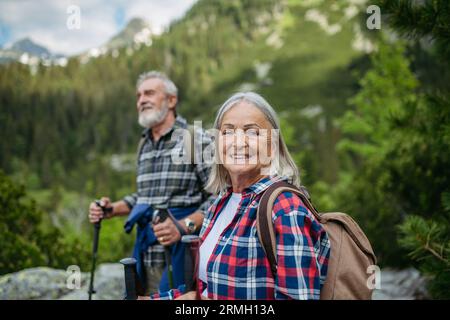 Potrait de femme âgée active randonnant avec son mari dans les montagnes d'automne. Banque D'Images