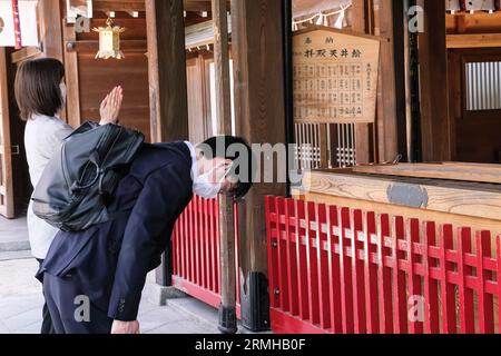 Japon, Kyushu, Fukuoka, Hakata. Adorateur priant au sanctuaire Shinto de Kushida Banque D'Images