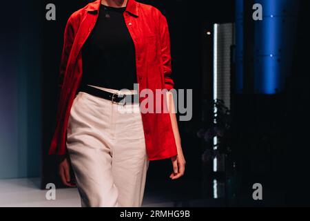 Pantalon blanc chic, haut noir et chemise rouge avec boutons sur le corps féminin. Détails fantaisie mode. Style, conception de vêtements et accessoires pour femmes. Banque D'Images