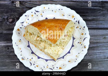 Fromage blanc à l'intérieur d'un morceau d'un pain ouzbek tandyr Nan, un type de pain d'Asie centrale, souvent décoré par estampage de motifs sur la pâte à l'aide d'un b. Banque D'Images