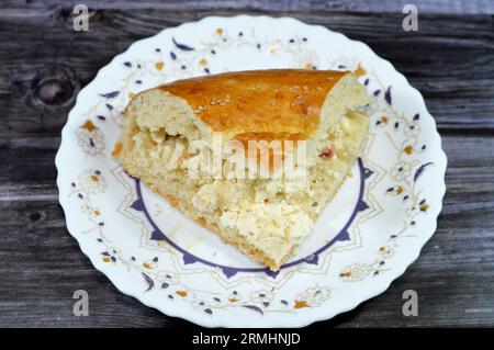 Fromage blanc à l'intérieur d'un morceau d'un pain ouzbek tandyr Nan, un type de pain d'Asie centrale, souvent décoré par estampage de motifs sur la pâte à l'aide d'un b. Banque D'Images