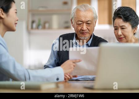 couple asiatique senior semble confus et suspect à un vendeur vendant des produits financiers Banque D'Images