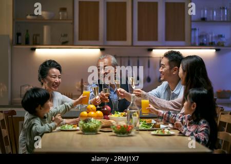 réunion de famille asiatique de trois générations à la maison célébrant les vacances en portant un toast Banque D'Images