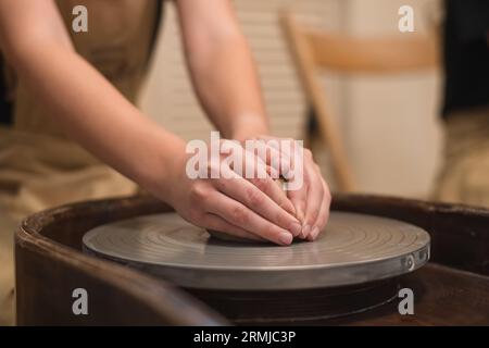 Potter girl travaille sur la roue de potier, faisant pot en céramique à partir d'argile dans l'atelier de poterie. Art et concept de passe-temps Banque D'Images