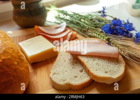 Traditional sandwich with a slice of sausage on a slice of bread and yellow cheese Stock Photo