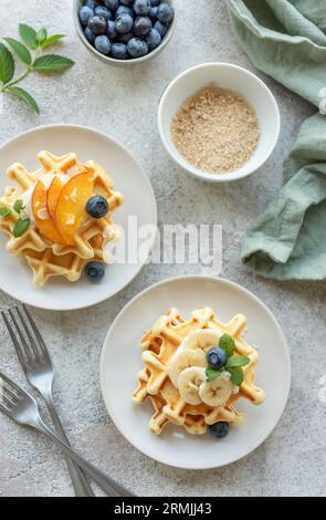 Gaufres belges avec fruits, bananes et miel. Cuisson maison. Concept de petits déjeuners sains. Banque D'Images