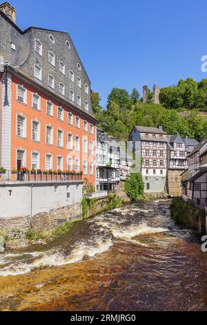 Maisons à colombages sur les rives de la Rur à Monschau avec les ruines de Haller en arrière-plan Banque D'Images