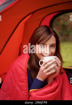 Teenage Girl Camping sur un terrain Banque D'Images