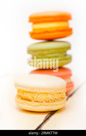 Macarons français colorés sur une table en bois rustique blanc Banque D'Images