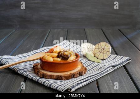 Cocotte en faïence avec ragoût de haricots, pudding noir et saucisse au chorizo Banque D'Images