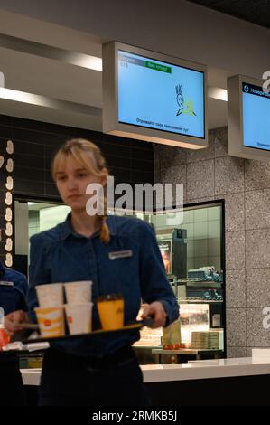 Ivano-Frankivsk, Ukraine, 7 juin 2023 : un serveur de McDonald's porte une commande prête à l'emploi sur un plateau, un restaurant de restauration rapide. Banque D'Images