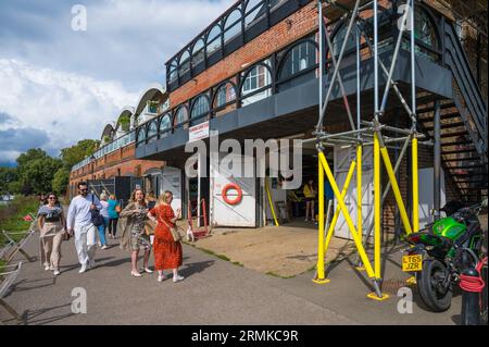 Les gens marchant sur le sentier de la Tamise lors d'une journée d'été passent par le Richmond Canoe Club Boathhouse. Richmond, Londres, Angleterre, Royaume-Uni Banque D'Images