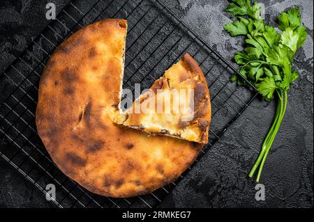 Tarte d'ossète cuite avec de la viande de boeuf et des herbes. Arrière-plan noir. Vue de dessus. Banque D'Images