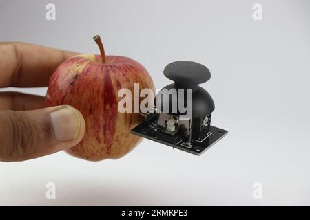 Apple avec module joystick attaché montrant le concept d'intégration de la technologie avec le monde organique Banque D'Images