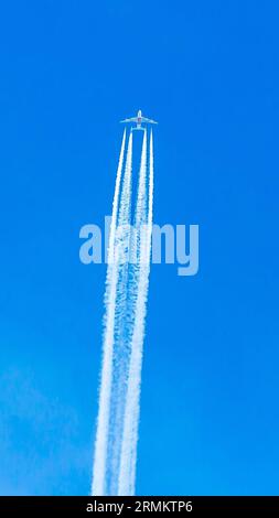 Avion quadrimoteur en vol avec traînées de condensation Banque D'Images