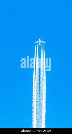 Avion quadrimoteur en vol avec traînées de condensation Banque D'Images