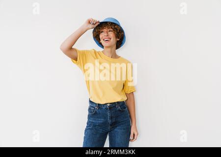 Joyeuse femme de gingembre d'âge moyen portant panama debout isolée sur un mur blanc Banque D'Images