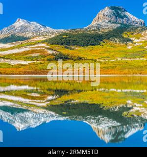 Coeur butte et plumes femme mountain reflété dans le lac vert en automne près de coeur Butte, Montana Banque D'Images