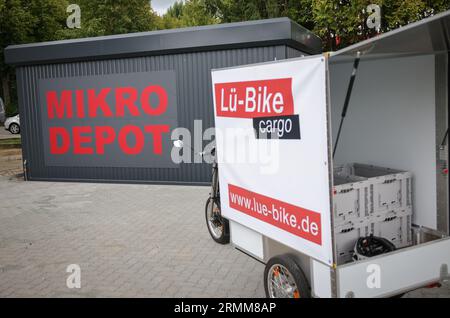 29 août 2023, Schleswig-Holstein, Lübeck : un vélo cargo à assistance électrique de Lü-Bike se trouve sur le parking lors de l'ouverture du premier microdépôt à Lübeck. Le dépôt est destiné à soulager la vieille ville de Lübeck du trafic de consignation et de livraison. Photo : Christian Charisius/dpa Banque D'Images