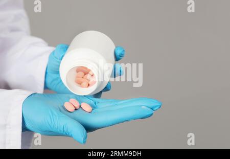 Gros plan des mains du docteur versant des pilules de Medical Bottle, Studio Banque D'Images