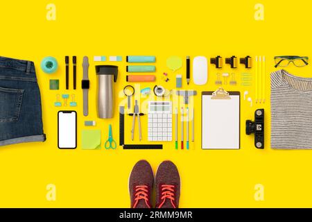 Papeterie, fournitures scolaires à plat avec maquette de smartphone. Retour à l'école plat sur fond jaune Banque D'Images