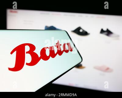 Smartphone avec logo de la société de chaussures Bata Corporation sur l'écran devant le site Web de l'entreprise. Concentrez-vous sur le centre gauche de l'écran du téléphone. Banque D'Images