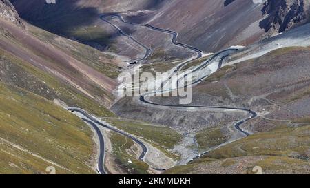 Urumqi. 23 août 2023. Cette photo aérienne prise le 23 août 2023 montre la vue le long de l'autoroute Duku dans la région autonome ouïgoure du Xinjiang, au nord-ouest de la Chine. L'autoroute Duku, considérée comme l'une des plus belles routes de Chine, est une section montagneuse pittoresque s'étendant sur plus de 500 kilomètres entre Douchanzi et Kuqa sur la route nationale chinoise 217 au Xinjiang. Route principale reliant le nord et le sud du Xinjiang, la Duku Highway est également célèbre pour ses paysages naturels spectaculaires, notamment ses glaciers, ses forêts et ses prairies. Crédit : Wang Peng/Xinhua/Alamy Live News Banque D'Images