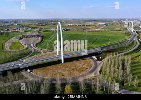 Vue zénithale aérienne d'un rond-point avec une arche du pont suspendu par Santiago Calatrava à Reggio Emilia. Reggio Emilia, Italie Banque D'Images