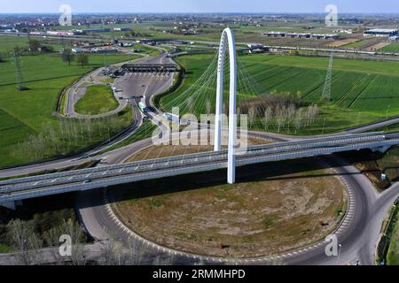 Vue zénithale aérienne d'un rond-point avec une arche du pont suspendu par Santiago Calatrava à Reggio Emilia. Reggio Emilia, Italie Banque D'Images