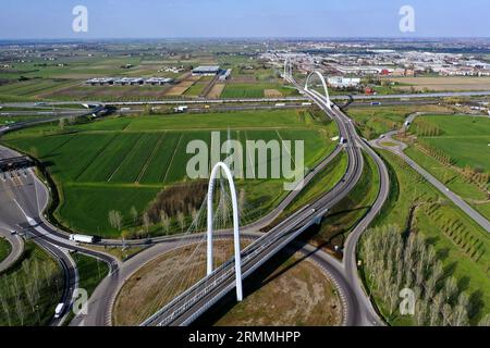 Vue zénithale aérienne d'un rond-point avec une arche du pont suspendu par Santiago Calatrava à Reggio Emilia. Reggio Emilia, Italie Banque D'Images