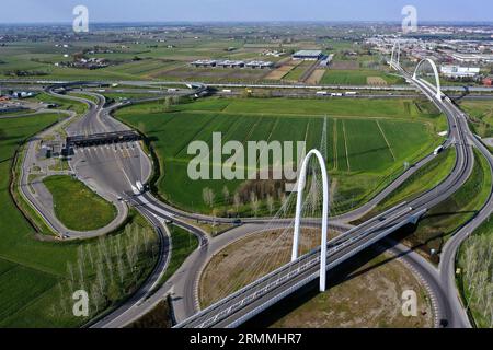 Vue zénithale aérienne d'un rond-point avec une arche du pont suspendu par Santiago Calatrava à Reggio Emilia. Reggio Emilia, Italie Banque D'Images