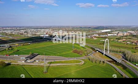 Vue zénithale aérienne d'un rond-point avec une arche du pont suspendu par Santiago Calatrava à Reggio Emilia. Reggio Emilia, Italie Banque D'Images