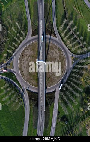 Vue zénithale aérienne d'un rond-point avec une arche du pont suspendu par Santiago Calatrava à Reggio Emilia. Reggio Emilia, Italie Banque D'Images