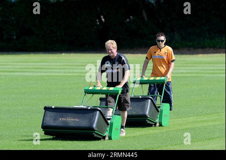 Le personnel du terrain tond de l'herbe sur le terrain d'entraînement du club de football Wolverhampton Wanderers Banque D'Images