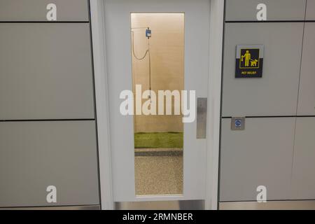 Vue rapprochée de la porte vitrée de la chambre pour soulager les animaux de compagnie à l'aéroport. ÉTATS-UNIS. New York. Banque D'Images