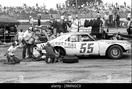 Les équipages amateurs de course de stock-car travaillent sur leurs voitures lors d'un arrêt au stand au Volusia Speedway à Barberville, en Floride, lors d'une course en 1984. Banque D'Images