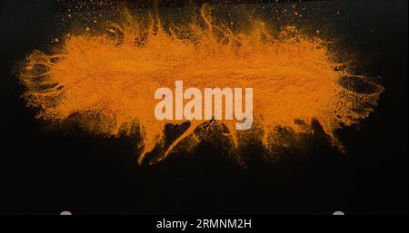 Curcuma, curcuma longa, poudre tombant sur fond noir, épices indiennes Banque D'Images