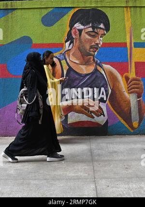 Mumbai, Maharashtra, Inde. 29 août 2023. Une femme musulmane portant un hijab passe devant une peinture murale représentant l'athlète indien Neeraj Chopra à Mumbai. Neeraj Chopra est devenu le premier Indien à remporter la médaille d'or au Championnat du monde d'athlétisme organisé à Budapest en Hongrie. Il a réussi à lancer le javelot à une distance de 88.17m qui lui a valu la médaille d'or devant le pakistanais Arshad Nadeem qui a remporté une médaille d'argent. (Image de crédit : © Ashish Vaishnav/SOPA Images via ZUMA Press Wire) USAGE ÉDITORIAL SEULEMENT! Non destiné à UN USAGE commercial ! Banque D'Images