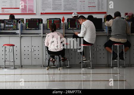 Fuyang, Chine. 28 août 2023. Plusieurs investisseurs sont attentifs aux changements dans l'indice composite de Shanghai affiché sur les écrans d'ordinateur du Fuyang Hua'an Securities Trading Office. Le ministère des Finances et l’Administration fiscale d’État ont annoncé dans un communiqué du 27 août que la Chine réduirait de moitié le droit de timbre sur les transactions boursières à partir du 28 août afin de revitaliser les marchés financiers et de renforcer la confiance des investisseurs. (Image de crédit : © Sheldon Cooper/SOPA Images via ZUMA Press Wire) USAGE ÉDITORIAL SEULEMENT! Non destiné à UN USAGE commercial ! Banque D'Images