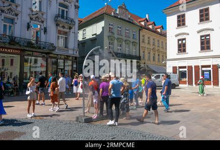 Bratislava, Slovaquie. 14 août 2023. Vue sur la place principale, Hlavne namestie. Les gens se refroidissent avec de l'eau vaporisée Banque D'Images